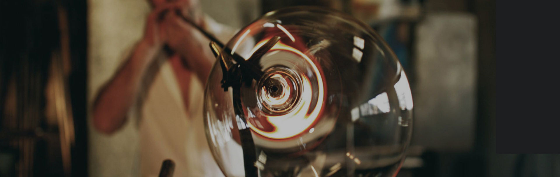 Ein Glasbläser bei der Herstellung von mundgeblasenen Weingläsern