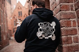 Eine Person trinkt Wein und trägt Lobenbergs Hoodie