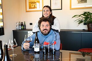 Zwei Winzer verkosten eine Flasche Wein