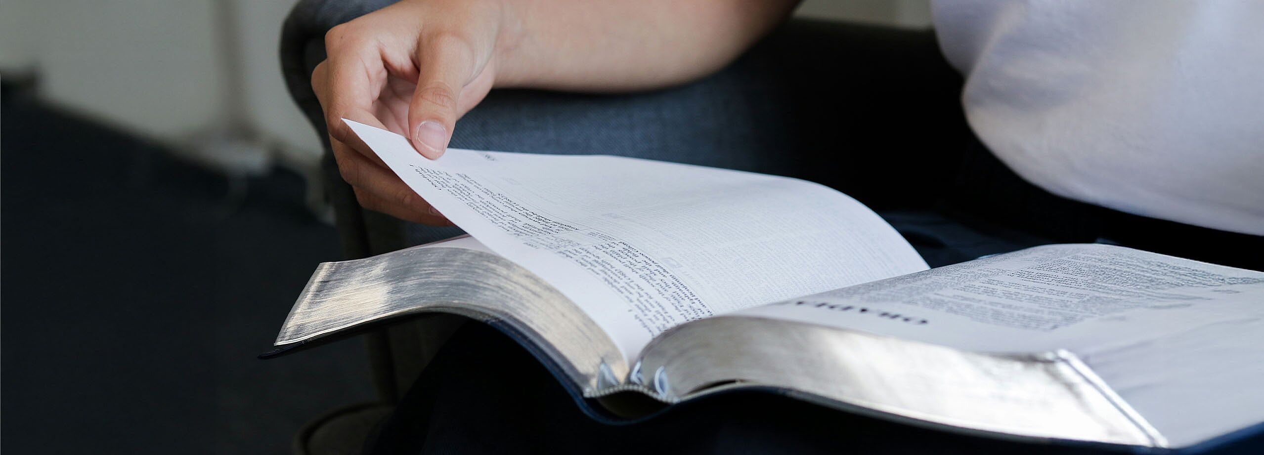 Person blättert in einem Buch
