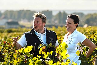 Winzer und Winzerin bei Sonnenschein auf dem Weinfeld Amiot-Servelle Winzer und Winzerin bei Sonnenschein auf dem Weinfeld Amiot-Servelle