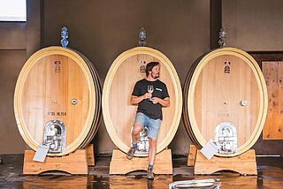 Matías Riccitelli vor Weinfässern