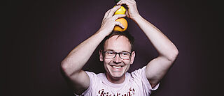 Jörn Goziewski stapelt Zitrusfrüchte auf dem Kopf und lächelt