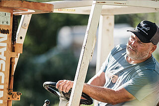 Person auf einer Ernte-Maschine auf dem Weinfeld Dunn Vineyards Mann auf einer Ernte-Maschine auf dem Weingut Dunn Vineyards