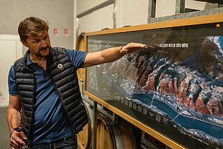 Ein Winzer zeigt auf eine Landkarte, zu sehen ist die Rhône Ein Winzer zeigt auf eine Landkarte, zu sehen ist die Rhône