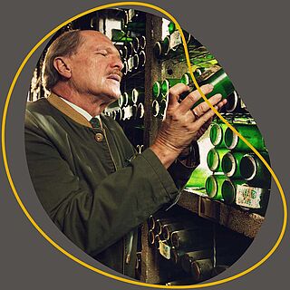 En mand tager en flaske fra en vinbutik