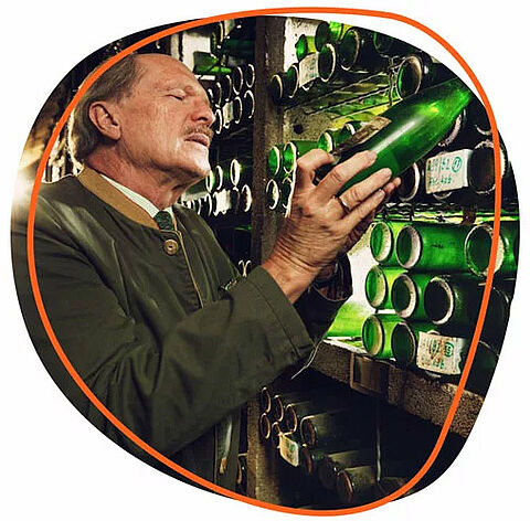 Ein Mann schaut nach einer Flasche in einem Flaschenlager