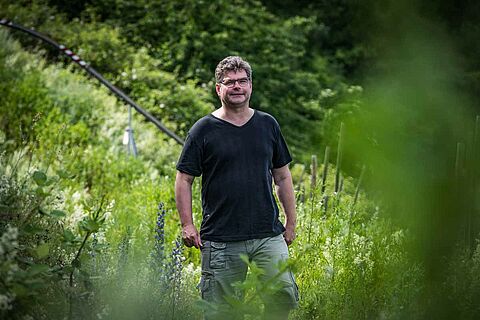 Winzer von Immich-Batterieberg steht im Weinberg