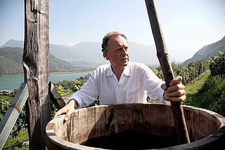 Mand i hvid skjorte og vinmarker med blå himmel i baggrunden