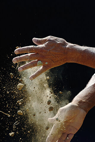 Hände die Erde abklopfen