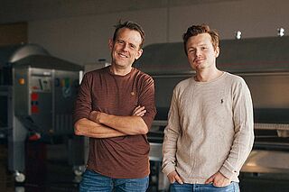 Winzer im Weinkeller Kran, mit Weintanks im Hintergrund Winzer im Weinkeller Kran, mit Weintanks im Hintergrund