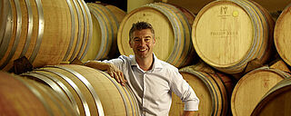 Phillip Kuhn im Weinkeller, Portrait, Weinfässer