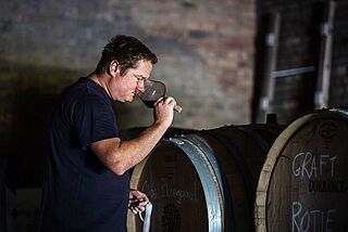 Van Loggerenberg steht im Keller und probiert Wein