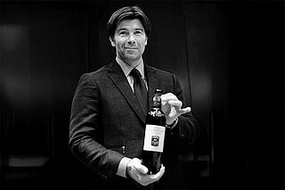 Mann hält Weinflasche