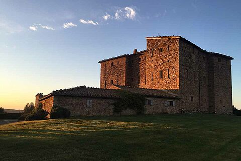 Castello Romitorio Weingut mit Schloss bei Sonnenuntergang