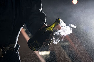 En åben flaske champagne, der lige er blevet tømt for tryk