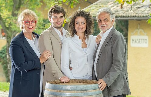 Winzerfamilie Endrizzi versammelt an einem Fass