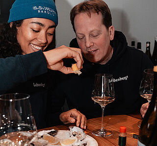 Zwei Personen essen Austern an einem Tisch