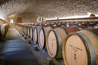 Weinkeller mit Weinfaessern der Domaine des Lambrays