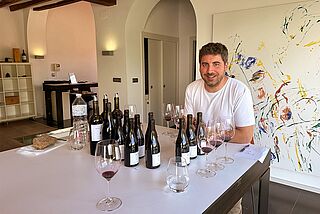 Der Winzer sitzt an einem Tisch mit Wein