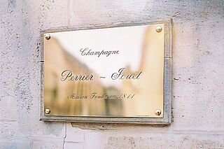 Schild des Weinguts Perrier Jouet an einer Steinmauer Schild des Weinguts Perrier Jouet an einer Steinmauer