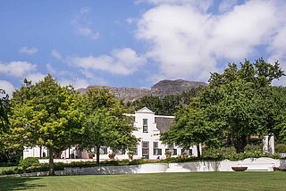Anwesen des Weinguts Klein Constantia mit Weinbergen im Hintergrund