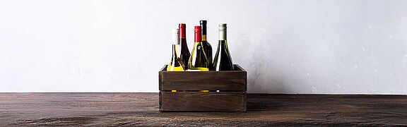 Eine Weinkiste mit ein paar Flaschen Wein darin