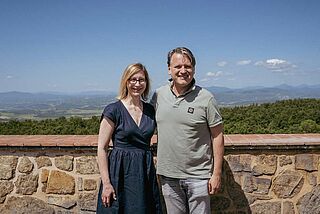 Anja und der Winzer vor einer Mauer