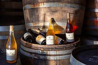 Weinflaschen von Enderle und Moll auf Weinfass