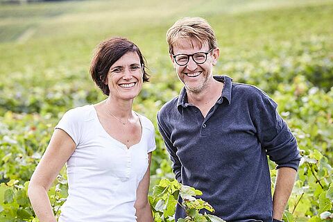 Winzer und Winzerin des Weinguts Lacourte-Godbillon vor einem Weinfeld
