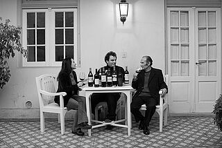 Drei Winzer sitzen an einem Tisch