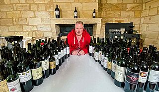 Heiner Lobenberg neben vielen Weinflaschen bei einer Verkostung