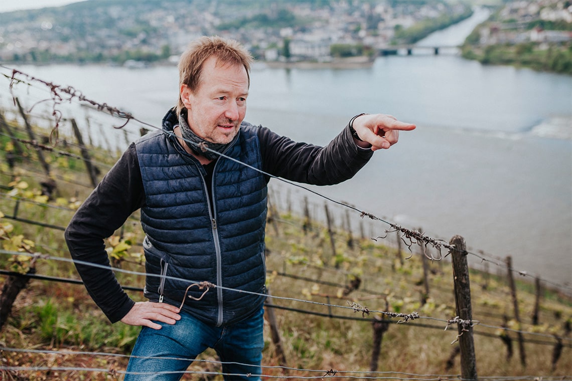 Der Winzer von Bischöfliches Weingut Rüdesheim steht auf dem Weinberg