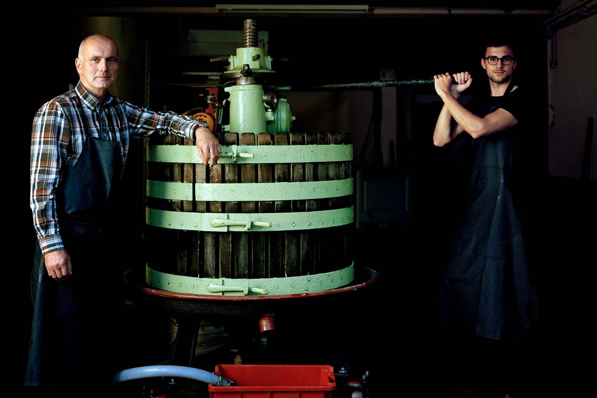 Sohn Christopher und Carl Loewen im Weinkeller an einem Holztank