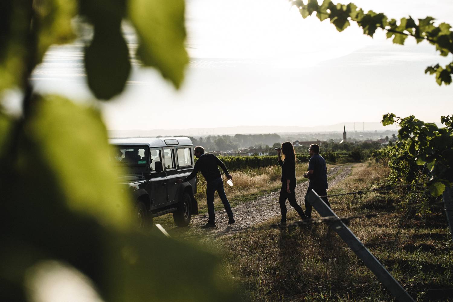 Christmann & Kauffmann Winzer im Weinberg mit Auto bei Sonnenuntergang